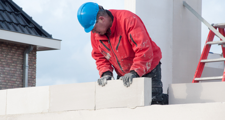 Man installing auto aerated concrete on building