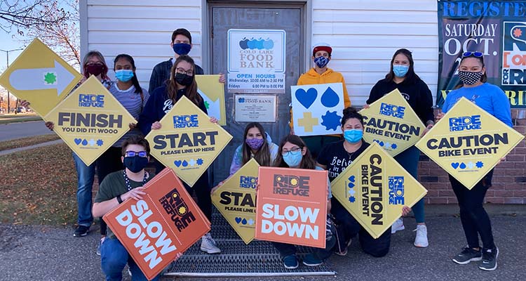 Students holding signs for the Ride for Refuge race in Cold Lake